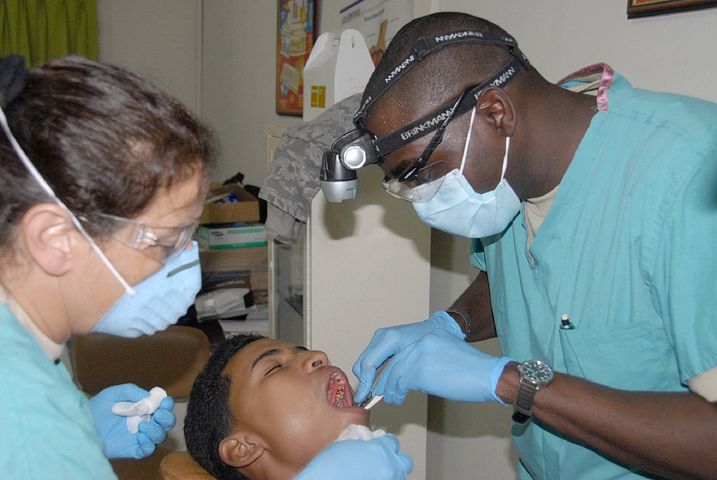 2 dentists checking a patient's mouth